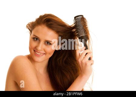 Belle jeune femme peignait ses cheveux avec une brosse isolée sur fond blanc Banque D'Images