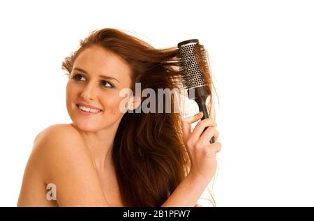 Belle jeune femme peignait ses cheveux avec une brosse isolée sur fond blanc Banque D'Images