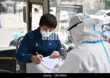 (200227) -- BEIJING, 27 février 2020 (Xinhua) -- un patient de COVID-19 récupéré écrit ses renseignements personnels sur un autobus de don de sang à Beijing, capitale de la Chine, 27 février 2020. Deux patients de l'infection du coronavirus nouveau ont fait don de plasma jeudi à Beijing. (Xinhua/Chen Zhonghao) Banque D'Images