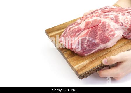 Col de porc frais brut sur planche à découper en bois isolé sur blanc. Planche à découper pour homme avec viande de porc. Banque D'Images