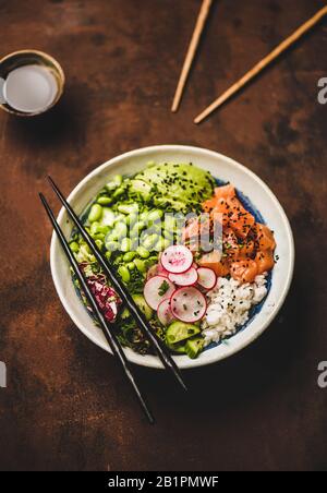 Bol de sélection de saumon sain avec légumes, légumes verts, riz, sauce soja Banque D'Images