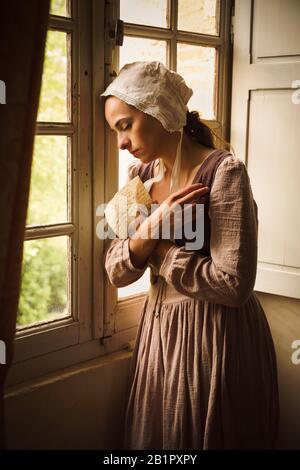 Style Vermeer portrait d'une jeune femme en costume renaissance la lecture d'une lettre à sa fenêtre Banque D'Images