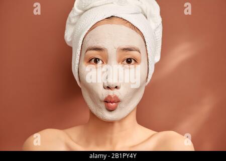 Belle jeune femme avec un masque d'argile. Traitement Spa, soins personnels et de santé de la peau Banque D'Images