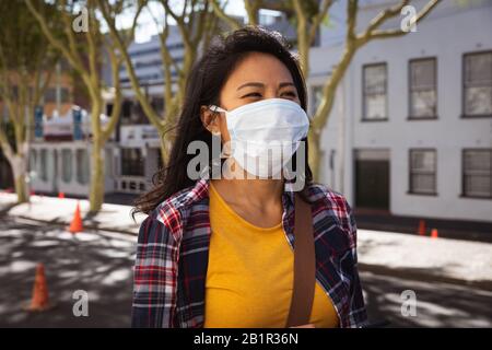 Femme portant un masque de visage de virus Corona Banque D'Images