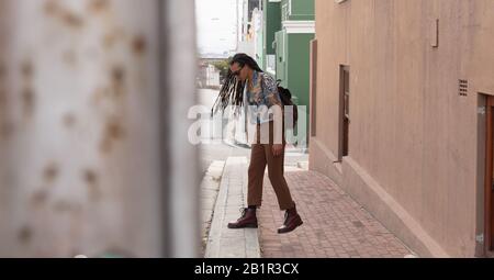 Homme de course mixte marchant dans la rue Banque D'Images