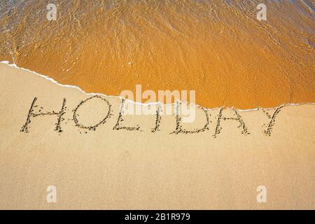 "Holiday" écrit dans le sable sur une plage, Allemagne Banque D'Images