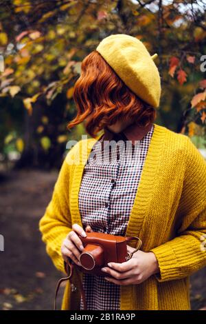 Une belle femme rousse avec un curly hairstyle promenade dans le parc Banque D'Images