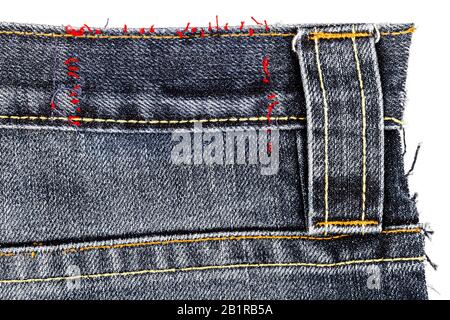 Morceau de tissu avec un jean noir déchiré de poche arrière isolé sur fond blanc. Les bords inégaux. Denim déchiré. Banque D'Images