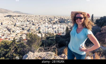 Une jeune jolie femme sourit à Athènes, en Grèce. Belles poses touristiques féminines donnant sur Athènes en été. Belle femme heureuse est sur le fond Banque D'Images