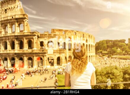 Le touriste féminin regarde le Colisée à Rome, en Italie. Le Colisée est un monument important de l'antiquité et est l'un des principaux attraits touristiques Banque D'Images