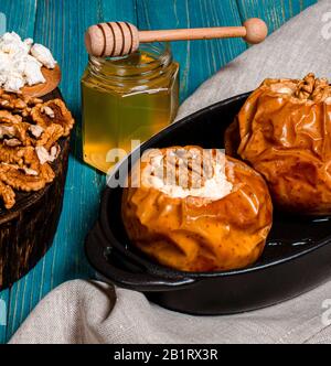 Alimentation saine. Pommes cuites au fromage cottage, miel et noix sous forme de stand de cuisson sur une table Banque D'Images
