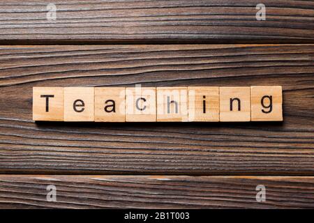 L'enseignement mot écrit sur une cale en bois. Texte sur l'enseignement de votre table en bois, design concept. Banque D'Images