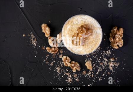 mousse au chocolat blanc recouverte de noix sur fond noir Banque D'Images