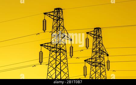 industrie de l'énergie électrique. Tours de transmission ou pylônes d'électricité avec fond de ciel doré Banque D'Images