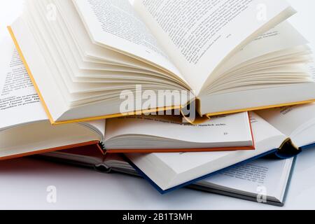Buecher liegen aufgeschlagen auf weissem Hintergund Banque D'Images