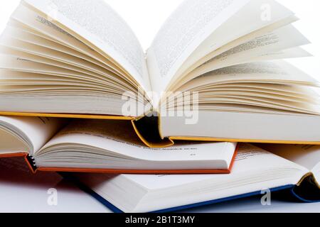 Buecher liegen aufgeschlagen auf weissem Hintergund Banque D'Images