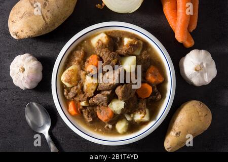 Ragoût de bœuf irlandais avec carottes et pommes de terre sur fond noir Banque D'Images