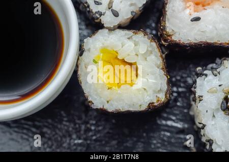 Mélangez les sushis veggie et les sushis de poisson sur la plaque en pierre noire, la nourriture japonaise Banque D'Images