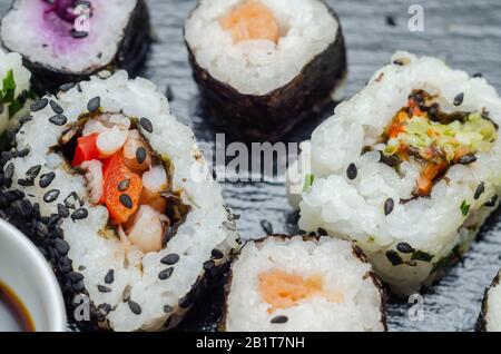 Mélangez les sushis veggie et les sushis de poisson sur la plaque en pierre noire, la nourriture japonaise Banque D'Images