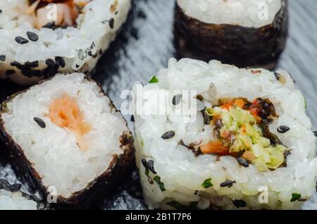 Mélangez les sushis veggie et les sushis de poisson sur la plaque en pierre noire, la nourriture japonaise Banque D'Images