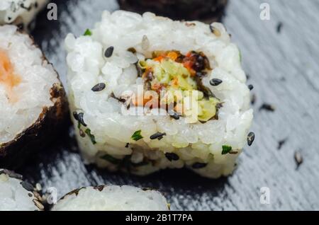 Mélangez les sushis veggie et les sushis de poisson sur la plaque en pierre noire, la nourriture japonaise Banque D'Images