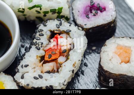 Mélangez les sushis veggie et les sushis de poisson sur la plaque en pierre noire, la nourriture japonaise Banque D'Images