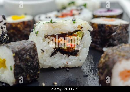 Mélangez les sushis veggie et les sushis de poisson sur la plaque en pierre noire, la nourriture japonaise Banque D'Images