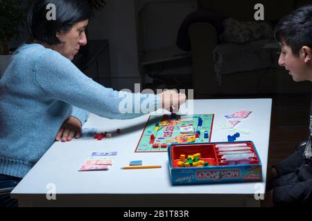 Mère et son fils adolescent jouant le jeu de société monopolistique ensemble Banque D'Images