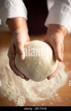 Boulangerie- clos-up d'un boulanger tenant une boule de levain de pâte en préparation de pain artisanal, Londres, Royaume-Uni Banque D'Images