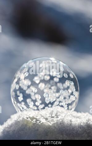 Gros plan sur le gel des bulles de savon dans la neige pendant un jour d'hiver. Banque D'Images