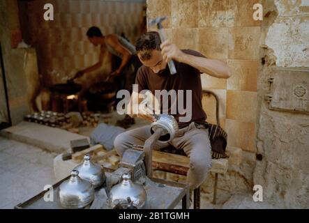 Photographie de rue - Artisan ouvrier de métal dans la ville des morts le Qarafa dans le Caire islamique historique en Egypte en Afrique du Nord. Profession de style de vie Banque D'Images