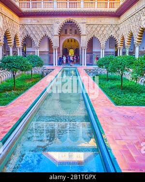 Séville, ESPAGNE - 1 OCTOBRE 2019: Le petit étang du palais de l'Alcazar reflète l'incroyable bâtiment du patio de las Doncellas avec des arcades sculptées, le Oct Banque D'Images