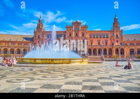 Séville, ESPAGNE - 1 OCTOBRE 2019: La grande fontaine au milieu de la Plaza de Espana est l'endroit le plus apprécié pour se détendre sous le spra rafraîchissant Banque D'Images