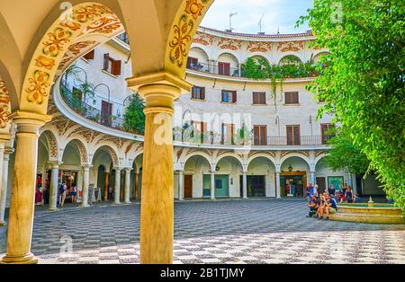 Séville, ESPAGNE - 1 OCTOBRE 2019: La vue à travers les arcades de marbre beaufiful sur la Plaza del Cabildo avec la petite fontaine si aimée parmi les lieux Banque D'Images