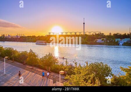 Séville, ESPAGNE - 1 OCTOBRE 2019: Les habitants de la ville longent la promenade Juan Carlos I dans la verdure environnante et le bruit de la rivière Guadalquivir Banque D'Images