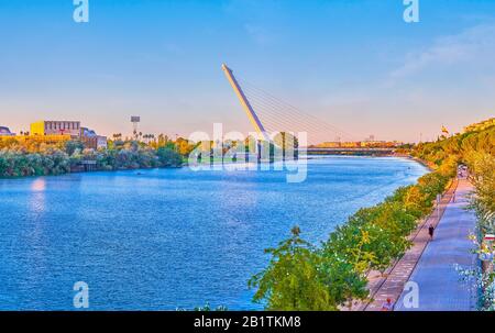 Séville, ESPAGNE - 1 OCTOBRE 2019: La belle vue sur la rivière Guadalquivir avec pont Alamillo et un quai piétonnier avec la marche locale pendant t Banque D'Images