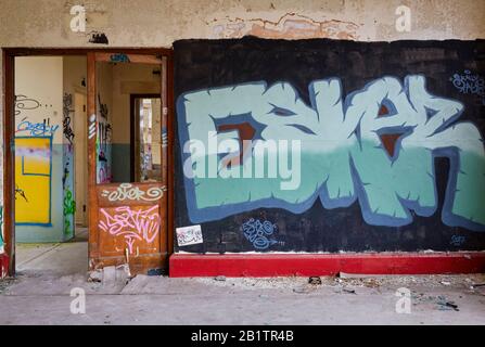 Bâtiments négligés, isolés, d'art urbain, avec des murs de graffitis peints en spray, usine de dérapage, peinture peeling. Banque D'Images