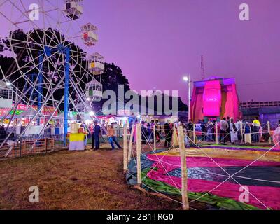 Tir de nuit d'une roue ferris dans le salon.les gens et les promenades dans le parc des expositions au plus grand salon. Ferris Wheel à la foire locale du comté.salon Coloré Banque D'Images