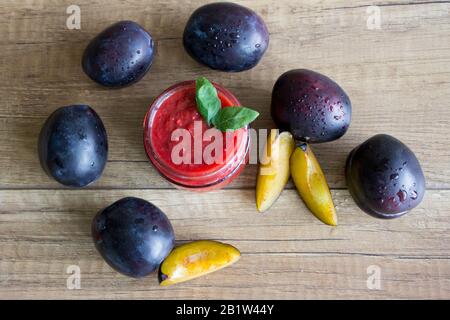 Sauce douce fraîche de prunes et légumes sur fond de bois Banque D'Images