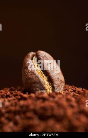 Grain de café sur le café moulu et fond brun. Gros plan. Banque D'Images