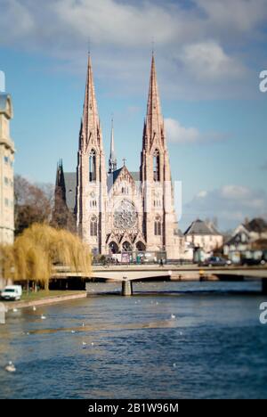 Strasbourg, France - 20 février 2013 : vue de face de l'église Saint-Paul de Strasbourg le bâtiment majeur de l'architecture gothique de Revival avec Rivière Malade et pont avec station de tramway Banque D'Images