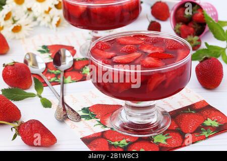 La gelée de fraises fraîches est située dans deux kremankah, en arrière-plan un bouquet de chamomilles Banque D'Images