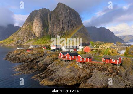 Petit village de pêcheurs Hamnoy sur les îles Lofoten/Norvège (célèbre attraction touristique) en été : ambiance de soirée avec l'arc-en-ciel. Banque D'Images