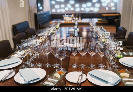 Assiettes blanches, couverts, nappes et verres pour le vin Banque D'Images