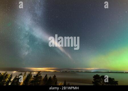 Faible lumière du Nord à l'horizon et phénomène atmosphérique 'SEVE' traversant la Voie lactée. Steve apparaît comme un ruban lumineux violet et vert dans le ciel à Banque D'Images