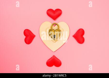 Fond rose avec cadenas romantique en forme de coeur, concept d'amour enchaîné. Banque D'Images