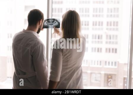 Deux médecins confiants discutent de la radiographie du patient dans la salle de réunion Banque D'Images