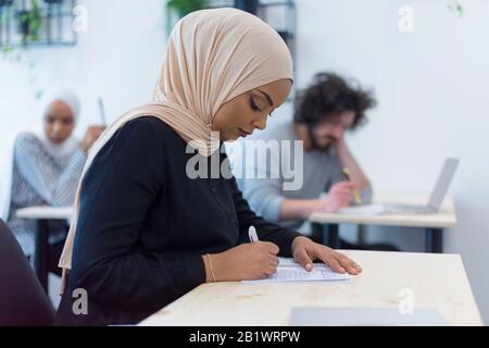 Groupe d'étudiants universitaires multiethniques travaillant sur des cours de pratique. Recherche de solutions pendant la classe. Banque D'Images