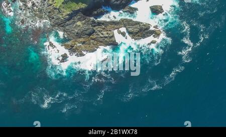 une prise aérienne aérienne aérienne survolant une île solitaire divisée au large de la côte du port de coffs, australie Banque D'Images