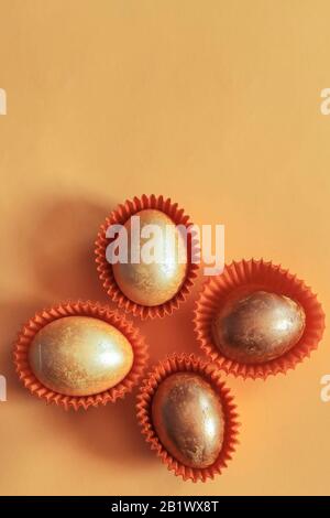 Œufs de pâques de couleur dorée sur fond jaune. Vue de dessus. Vue de dessus. Image plate des fêtes de pâques Banque D'Images